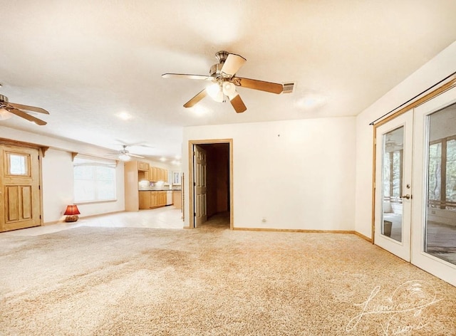 unfurnished room featuring plenty of natural light, light colored carpet, and french doors