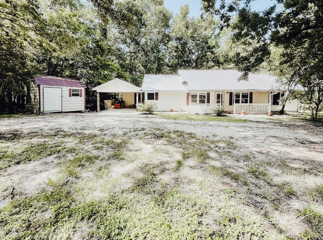 ranch-style house featuring a storage shed and a porch