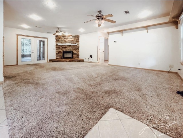 unfurnished living room with carpet floors, ceiling fan, french doors, and a fireplace