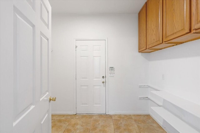 laundry area with light tile patterned floors