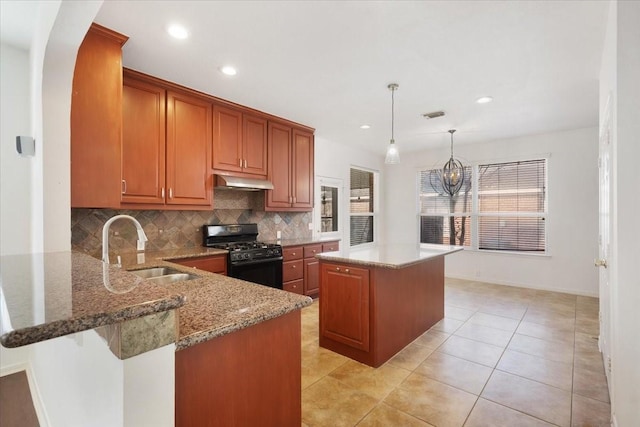 kitchen featuring a center island, kitchen peninsula, sink, black range with gas cooktop, and hanging light fixtures