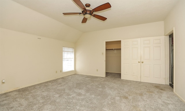 unfurnished bedroom featuring ceiling fan, light carpet, a closet, and lofted ceiling