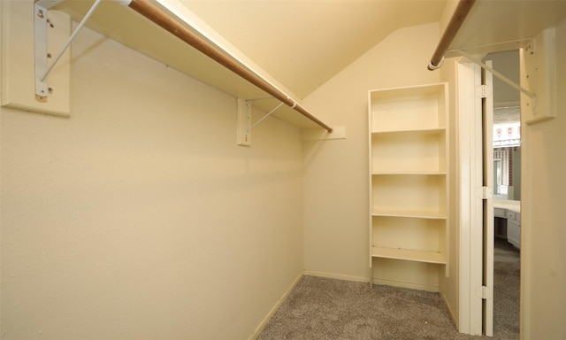 spacious closet featuring carpet flooring and lofted ceiling