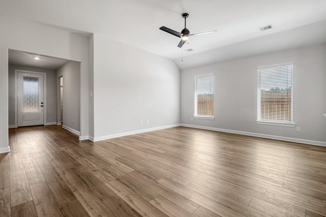 spare room with ceiling fan, light wood-type flooring, and vaulted ceiling