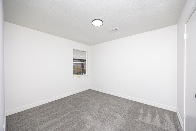 carpeted empty room with a textured ceiling