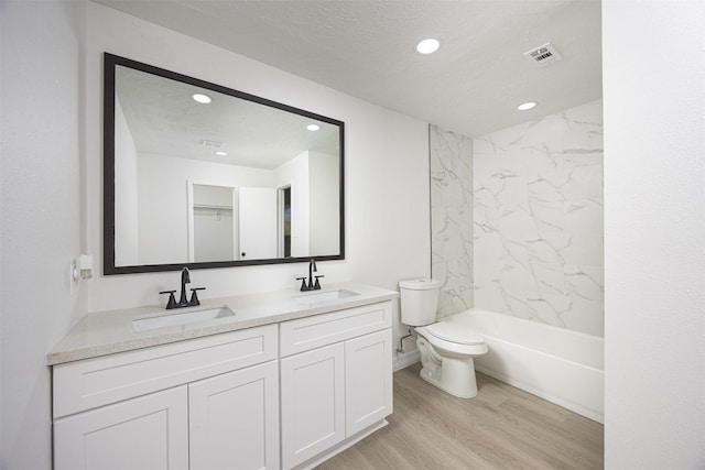 full bathroom with toilet, vanity, wood-type flooring, and a textured ceiling