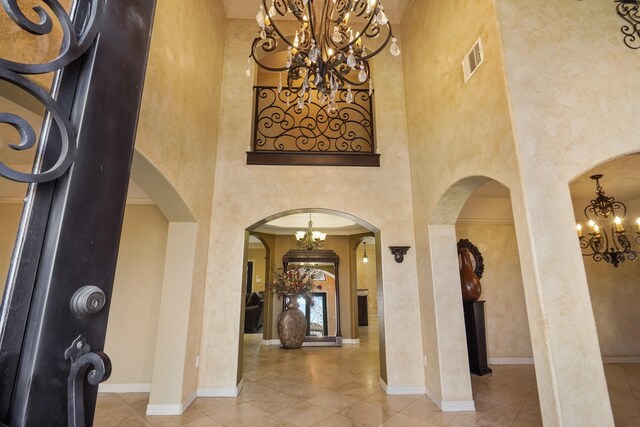 foyer entrance with a towering ceiling and crown molding