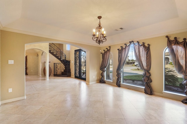 unfurnished room featuring a tray ceiling and an inviting chandelier