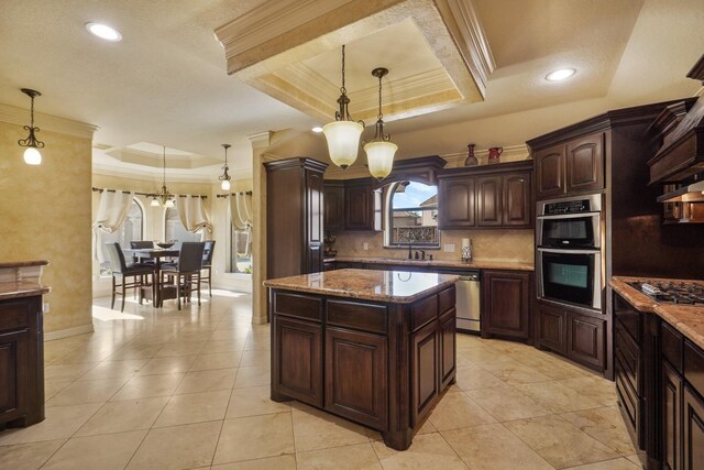 kitchen featuring decorative light fixtures, a tray ceiling, dark brown cabinets, and a notable chandelier