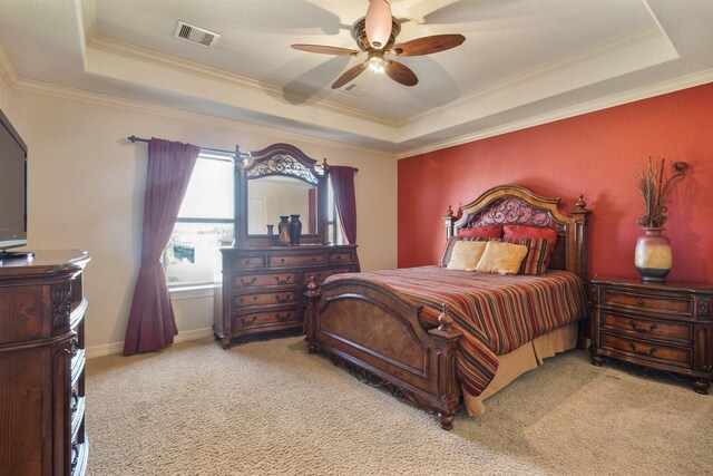 bedroom featuring ceiling fan, light colored carpet, a tray ceiling, and ornamental molding