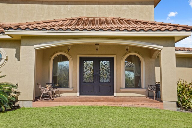 doorway to property featuring a yard and french doors