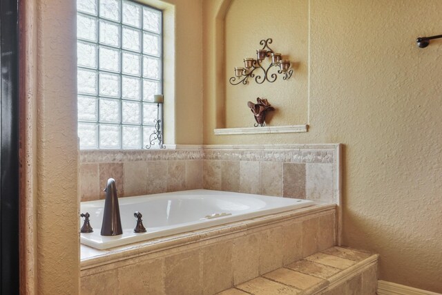 bathroom with tiled bath and a wealth of natural light