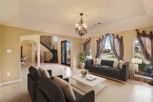 tiled living room featuring a notable chandelier and a raised ceiling