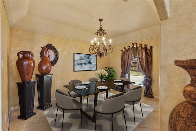 tiled dining room with a tray ceiling and an inviting chandelier