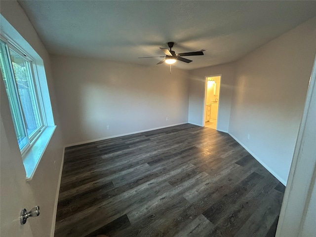 empty room with ceiling fan and dark wood-type flooring