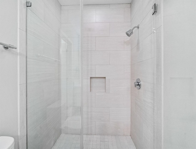 bathroom featuring an enclosed shower and toilet