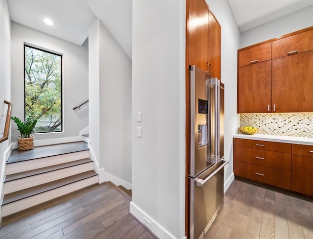 kitchen featuring wood-type flooring, backsplash, and high end refrigerator