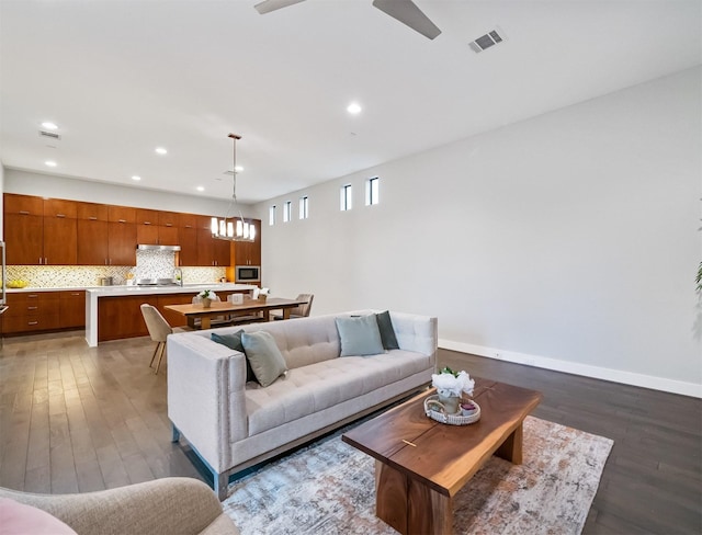 living room featuring ceiling fan and dark hardwood / wood-style floors