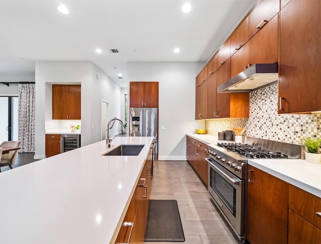 kitchen featuring decorative backsplash, sink, beverage cooler, and appliances with stainless steel finishes