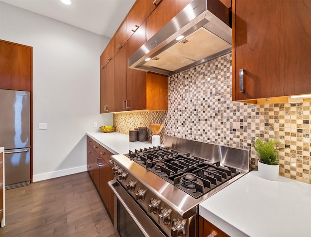 kitchen with range hood, dark hardwood / wood-style floors, appliances with stainless steel finishes, and tasteful backsplash