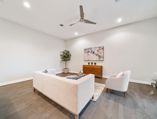 living room with ceiling fan and dark hardwood / wood-style flooring