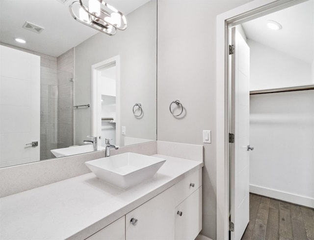 bathroom featuring a shower with door and vanity