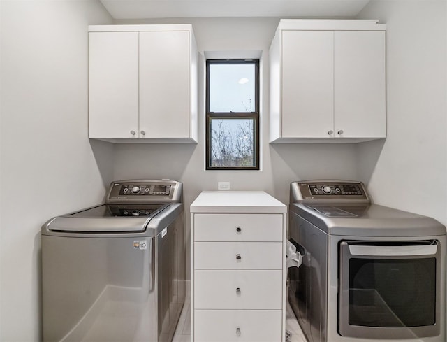 clothes washing area with cabinets and independent washer and dryer