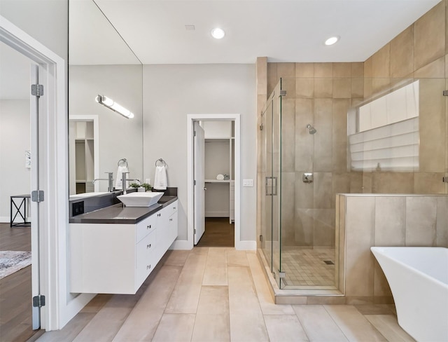 bathroom featuring independent shower and bath, tile patterned flooring, and vanity