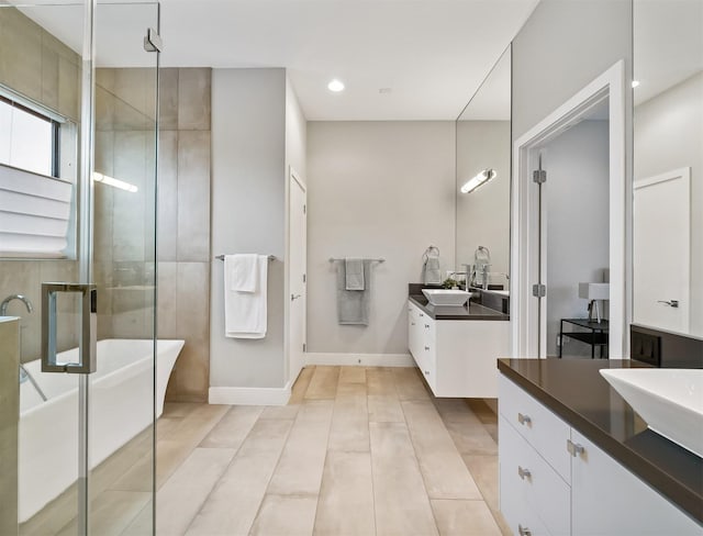 bathroom featuring shower with separate bathtub and vanity