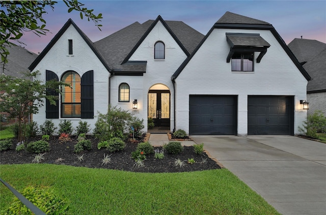 french country style house with a garage and french doors