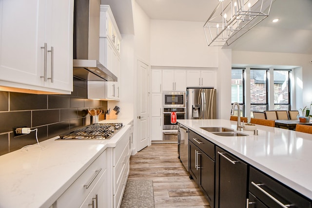 kitchen with decorative light fixtures, white cabinets, appliances with stainless steel finishes, and sink