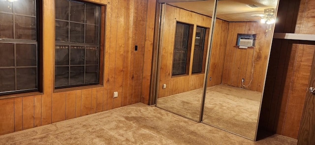 hallway with wood walls, a wall mounted air conditioner, and carpet flooring