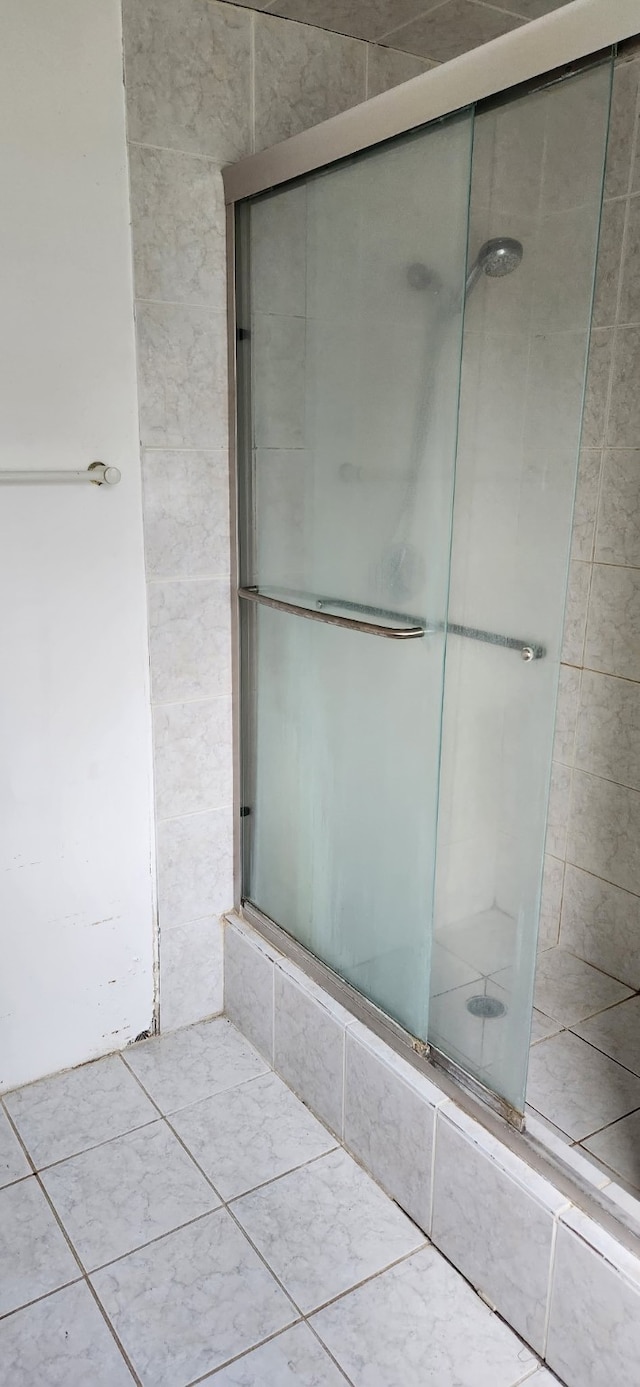 full bathroom with a shower stall and tile patterned floors