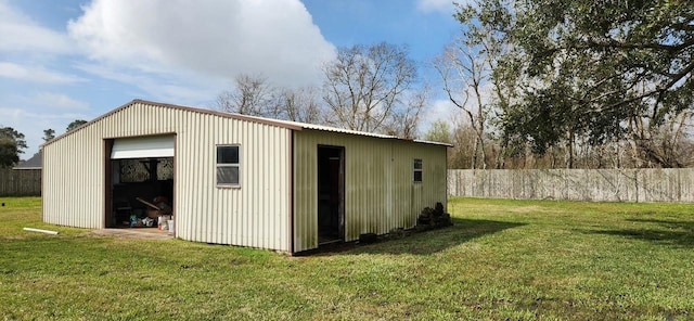 view of outdoor structure featuring fence and an outbuilding