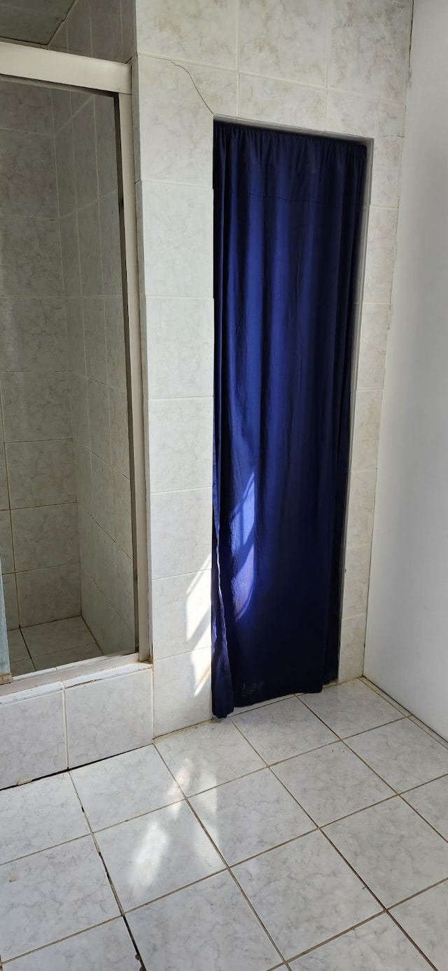 full bathroom featuring a stall shower and tile patterned flooring