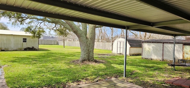 view of yard featuring an outbuilding, a shed, and fence