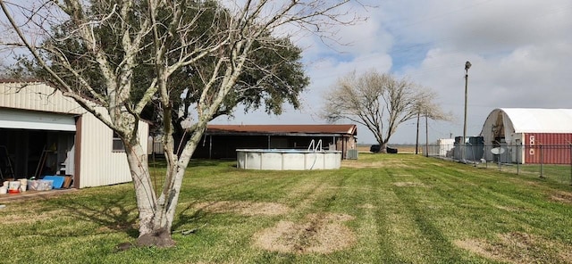 view of yard featuring fence, a fenced in pool, and an outdoor structure