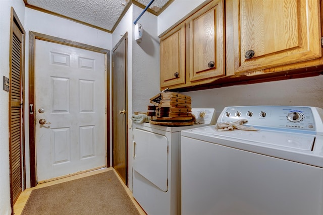 2180 Washington Ave, Alvin, TX 77511 - clothes washing area featuring washing machine and dryer, a textured ceiling, and cabinet space