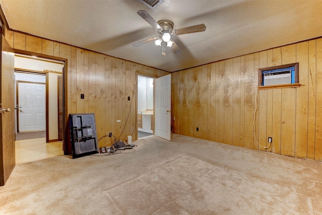 2180 Washington Ave, Alvin, TX 77511 - empty room with wood walls, ceiling fan, visible vents, and carpet flooring