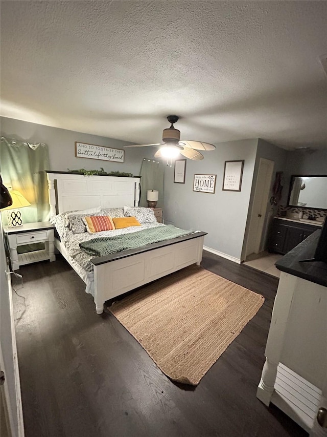 bedroom with ceiling fan, a textured ceiling, and dark hardwood / wood-style floors