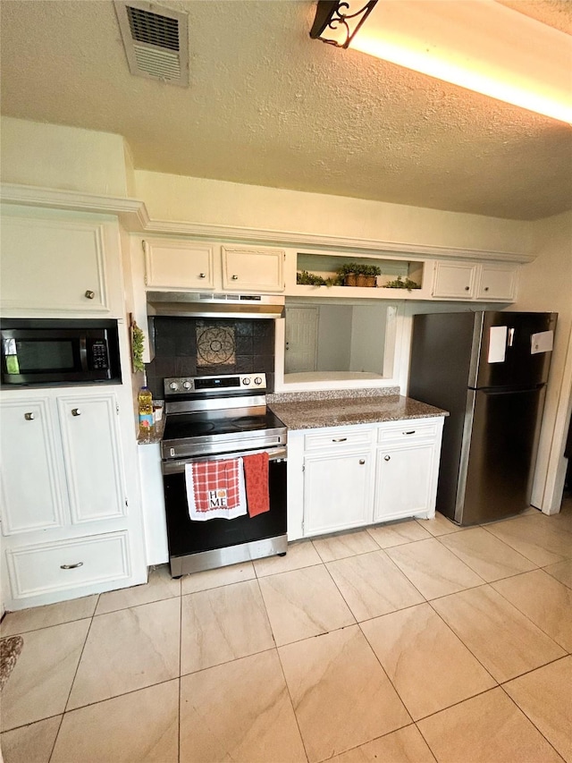 kitchen featuring a textured ceiling, light tile patterned floors, appliances with stainless steel finishes, and white cabinets