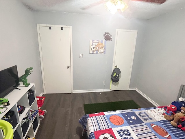 bedroom with ceiling fan, a textured ceiling, and dark hardwood / wood-style flooring