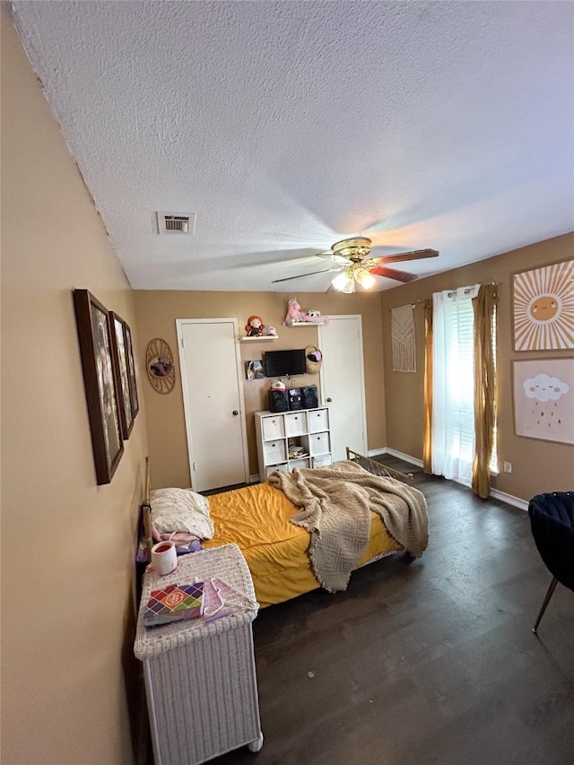 bedroom with ceiling fan and a textured ceiling