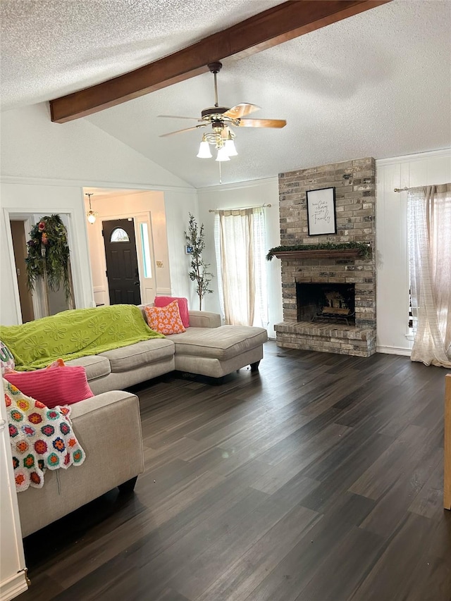 living room featuring ceiling fan, dark hardwood / wood-style floors, a fireplace, vaulted ceiling with beams, and a textured ceiling