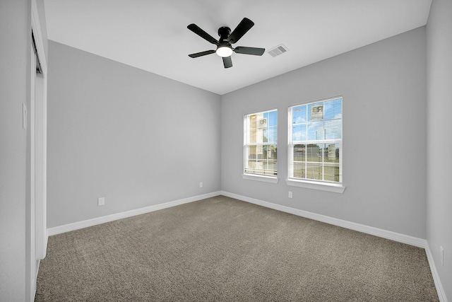 carpeted spare room featuring ceiling fan