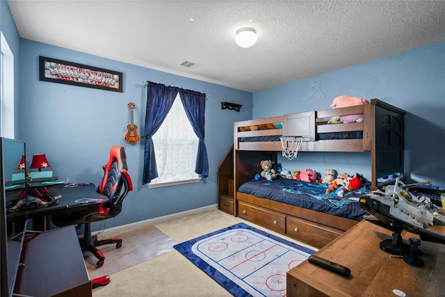 bedroom featuring light carpet and a textured ceiling