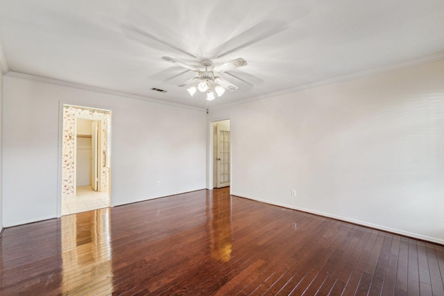 unfurnished room with visible vents, wood finished floors, and ornamental molding