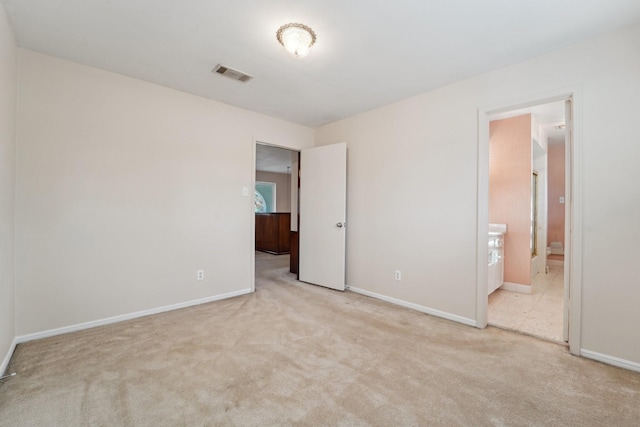 unfurnished bedroom featuring light carpet, baseboards, visible vents, and connected bathroom