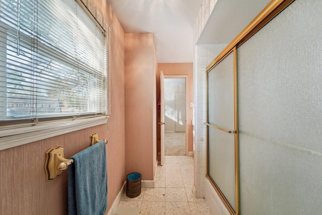 bathroom with enclosed tub / shower combo and wooden walls