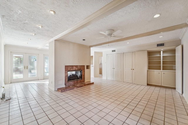 unfurnished living room featuring a textured ceiling, a premium fireplace, french doors, ornamental molding, and ceiling fan